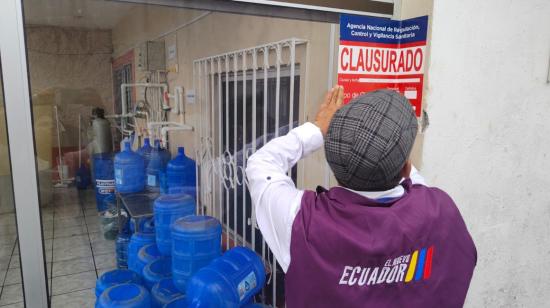 Un funcionario del Arcsa clausurando una planta de agua en Quevedo, 19 de julio de 2024.