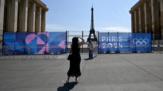Una mujer posa en el Trocadero frente a la Torre Eiffel parcialmente oculta por una valla, antes de los Juegos Olímpicos de París 2024, el 19 de julio de 2024.