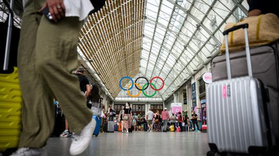 Los pasajeros caminan bajo los anillos olímpicos en la estación de tren Gare de Lyon, el 21 de julio de 2024, antes de los Juegos Olímpicos y Paralímpicos de París 2024.