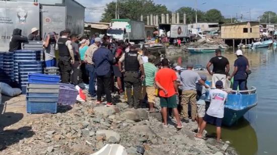 Personal de la Policía y de Bajo Alto, provincia de El Oro, observan los cuerpos de los pescadores en el bote.