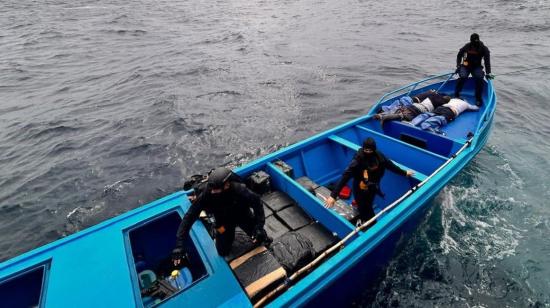 Tres efectivos de las fuerzas del Estado revisan el contenido y aprehenden a tres sujetos en una lancha que transportaba droga cerca de las Islas Galápagos, el 26 de julio de 2024.