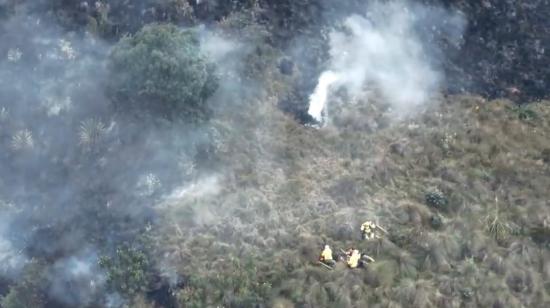 Bomberos y brigadistas atienden un incendio forestal en Pucán, Cuenca, en la tarde del 29 de julio de 2024.