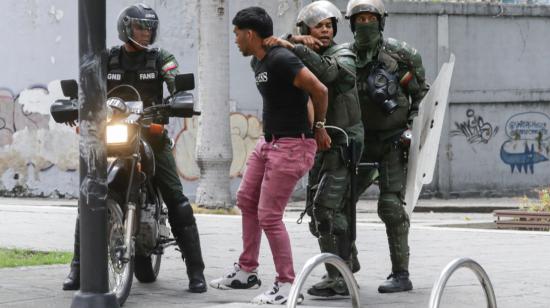 Integrantes de la Guardia Nacional Bolivariana detienen a un manifestante opositor,