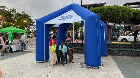 Un funcionario del SRI ofrece información a ciudadanos en un stand ubicado en una plaza, en el cantón Santa Cruz, en Galápagos, el 30 de julio de 2024. Imagen referencial.