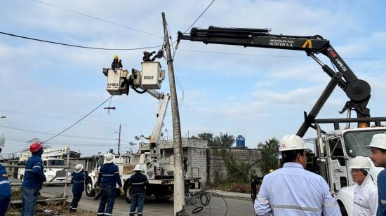 Técnicos de CNEL ejecutan trabajos de mantenimiento en un poste de luz.