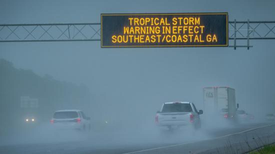 Vehículos pasan por debajo de una señal de advertencia por el paso de la tormenta tropical Debby, el 5 de agosto de 2024 en una localidad de Georgia, Estados Unidos.