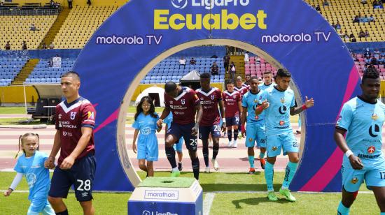 Los jugadores de Universidad Católica y Libertad salen a la cancha del estadio Atahualpa, el 10 de agosto de 2024.