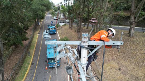 Un trabajador de la Empresa Eléctrica Quito realiza labores de mantenimiento en el norte de Quito, el 9 de agosto de 2024. Imagen referencial.