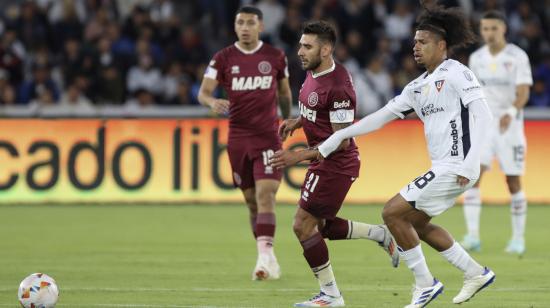 Marco Angulo, de Liga, disputa un balón con Eduardo Salvio, de Lanús, el miércoles 14 de agosto en el estadio Rodrigo Paz Delgado, por la Copa Sudamericana.