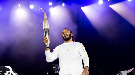 El atleta francés Helios Latchoumanaya sostiene la antorcha paralímpica durante un concierto en París, el 25 de agosto de 2024.