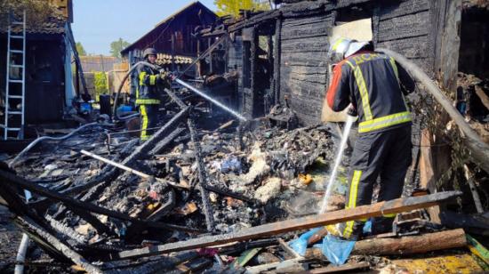 Bomberos trabajan en el lugar tras un ataque aéreo, en la región de Kiev, este 26 de agosto.