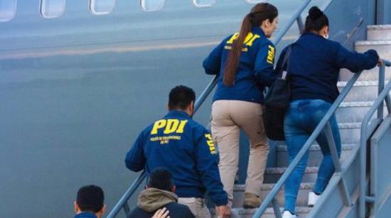 Funcionarios chilenos escoltan a extranjeros hasta el avión que los sacará de Chile.