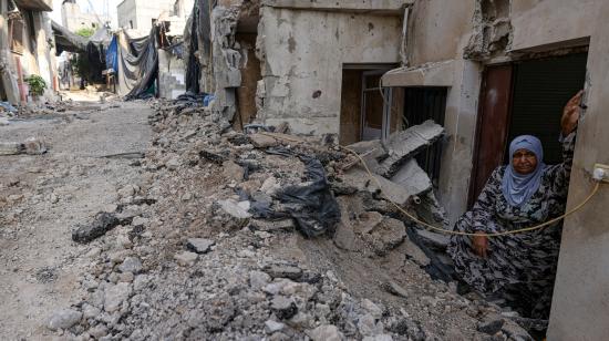 Una mujer palestina en la puerta de su casa. Se observa una calle donde maquinaria israelí retiró el asfalto, en el campo de refugiados de Nur Shams, cerca de Tulkarem, en Cisjordania.