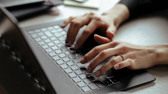 Persona escribiendo en el teclado de una laptop. Imagen referencial.