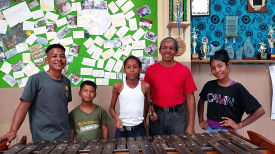 Jimmy Sinisterra (de rojo), director del grupo de música y danza Afromestizo Candente, con parte de sus alumnos en la cooperativa Andrés Quiñonez de la Isla Trinitaria, al sur de Guayaquil.