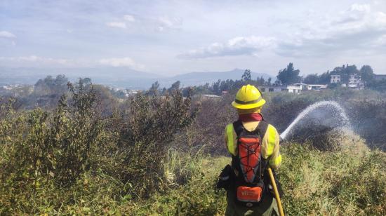 Un bombero combate el incendio en la Autopista General Rumiñahui de Quito, el 11 de septiembre de 2024.