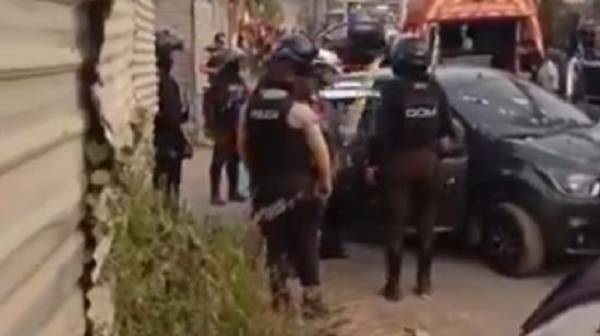 Policías custodian el carro negro en que viajaban los sospechosos en Monte Sinaí, el 15 de septiembre de 2024.