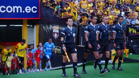 Los árbitros del partido entre Barcelona y Macará salen a la cancha del estadio Banco Pichincha, en Guayaquil, el 15 de septiembre de 2024.