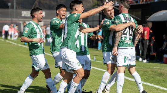 Damián Díaz (d), volante de Banfield, es felicitado por sus compañeros tras marcar de tiro libre ante Barracas Central, este 16 de septiembre.