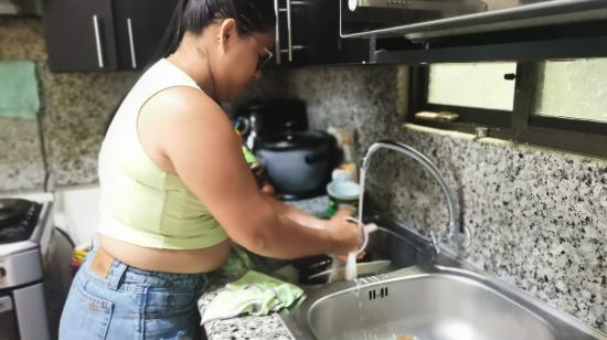 Un ama de casa lava platos en Los Tubos, de la Sergio Toral II, en donde el agua potable se inauguró el julio pasado. El noroeste de Guayaquil será uno de los sectores en los que más tarde en restablecerse el servicio tras los apagones de ocho horas.