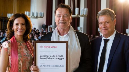 En el centro, Arnold Schwarzenegger mostrando su título de doctor honoris causa de la Universidad Hertie de Berlín.