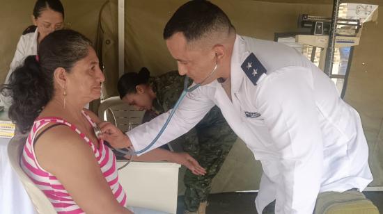 Un miembro del Ejército, con especialidad en Medicina, atiende a una paciente en una jornada de salud en el cantón Ponce Enríquez.