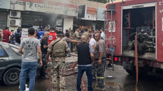 Personas y personal de emergencia en un lugar de Saida, en el sur de Líbano, donde se reportó la explosión de un dispositivo el 18 de septiembre de 2024.