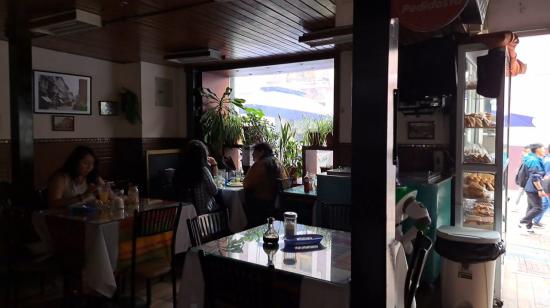 Un restaurante en Quito atiende en penumbra, en abril de 2024, por los cortes de luz programados.