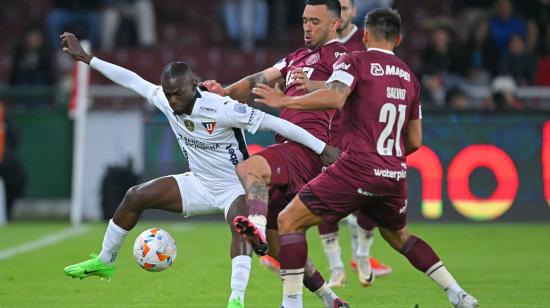 El delantero de Liga de Quito, Freddy Mina y el defensor de Lanús, Nery Domínguez  luchan por el balón durante el partido de ida de los octavos de final de la Copa Sudamericana.