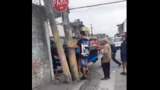 Vecinos mueven una camioneta de la empresa pública municipal Segura EP que derribó una pared y ocasionó la muerte de una pequeña niña y su madre en el sur de Guayaquil.