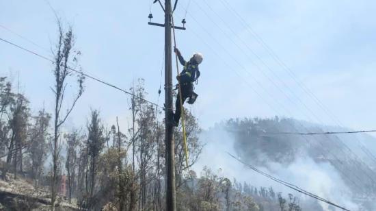 Un trabajador de la Empresa Eléctrica Quito inspecciona este 25 de septiembre la zona afectada por el incendio en Guápulo.