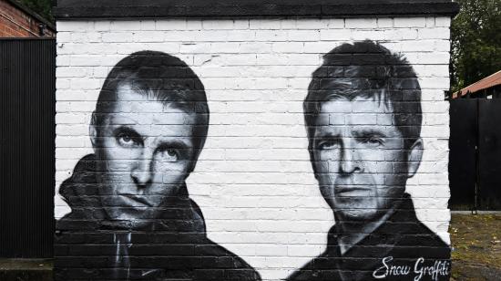 Un mural representa a Liam Gallagher (izq) y Noel Gallagher, miembros de la banda británica de rock Oasis, que anunció su regreso.