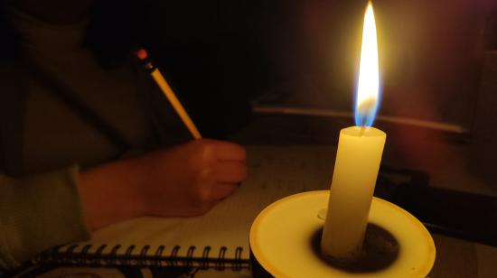 Una estudiante realiza tareas con ayuda de una vela, ante los cortes de luz. Habrá suspensión del servicio el 6 de octubre en Cuenca.