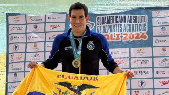 El nadador ecuatoriano, Esteban Enderica, posa con la bandera de Ecuador luego de ganar los 5 kilómetros en el Sudamericano de Aguas Abiertas, el domingo 6 de octubre de 2024.