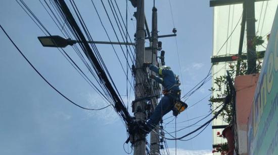 Un trabajador de la Empresa Eléctrica Quito (EEQ) realiza trabajos de mantenimiento en el sector de La Florida, en el norte de Quito, el 4 de octubre de 2024.