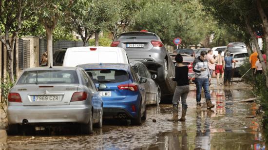 Varias personas junto a vehículos dañados por las intensas lluvias de la fuerte DANA que afecta especialmente el sur y el este de la península ibérica, el 30 de octubre de 2024 en Picaña.