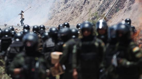 Un hombre se enfrenta con miembros de la Policía Militar Boliviana durante un bloqueo por simpatizantes del expresidente de Bolivia, Evo Morales (2006-2019) este viernes, en Parotani (Bolivia). Un gran contingente de policías y militares bolivianos desbloquean las carreteras tomadas por los seguidores de Morales desde hace 19 días, medida que ejercen en defensa de su líder ante una posible orden de captura en su contra por un caso de trata de personas y estupro.