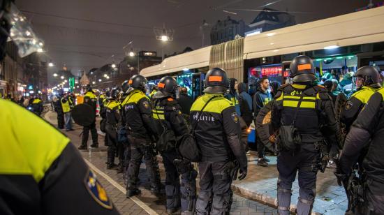 Oficiales de policía realizan un cordón de seguridad al rededor de un bus tras un partido en el que estuvieron presentes hinchas israelíes, el 8 de noviembre de 2024 en Ámsterdam, Países Bajos.