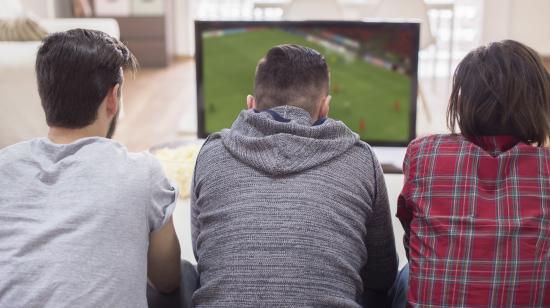 Imagen referencial de hombres mirando un partido de fútbol por televisión.