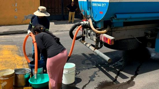 Tanquero entrega agua potable a una ciudadana en Quito.