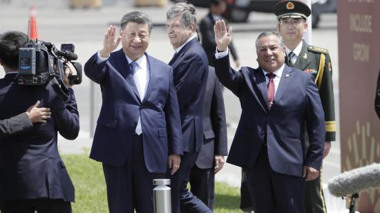 El presidente de China, Xi Jinping, junto al presidente del Consejo de Ministros de Perú, Gustavo Adrianzén, saludan a las cámaras en una base aérea de Lima, el 14 de noviembre de 2024.