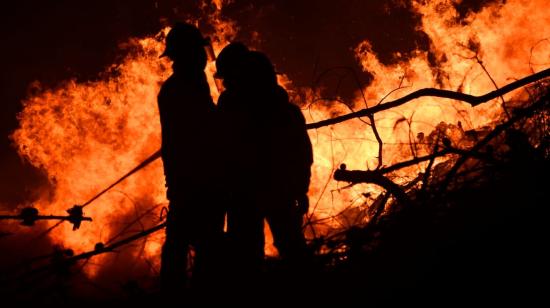 bomberos en medio de un incendio forestal en Loja