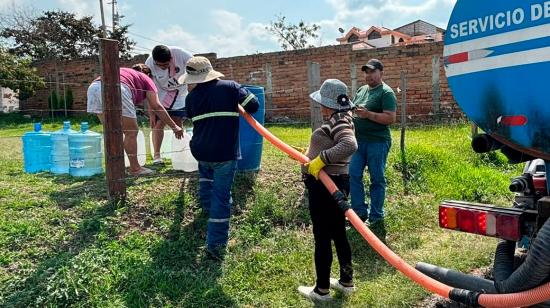 Ciudadanos reciben agua potable con un tanquero en Quito.