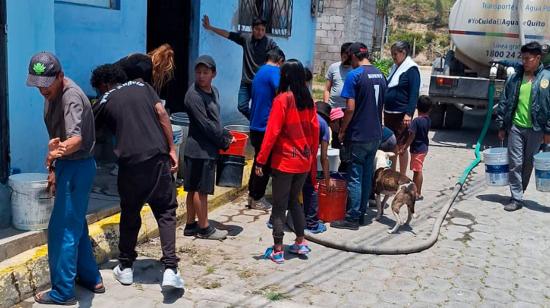 Moradores sin agua en Quito reciben el líquido vital con un tanquero.