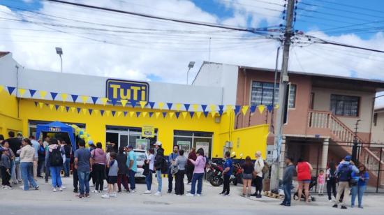 Personas hacen fila en los exteriores de una tienda Tuti en Cuenca