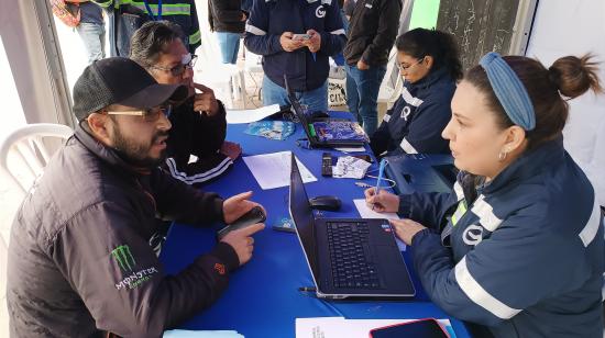 Funcionarios de la Empresa Eléctrica Quito responden dudas de usuarios en la parroquia de Nono, en Quito. Foto de septiembre de 2024.