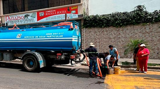 Moradores de Quito con cortes de agua reciben el líquido vital con tanqueros.