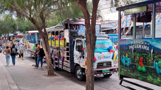 'Chivas' estacionadas en una calle de Quito mientras esperan para salir.