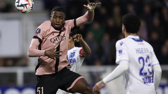 Willian Pacho, defensa ecuatoriano del PSG, despeja un balón por alto, este viernes 6 de diciembre ante al Auxerre, por la Liga francesa.