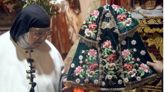 Una religiosa enseña el traje del niño viajero de Cuenca